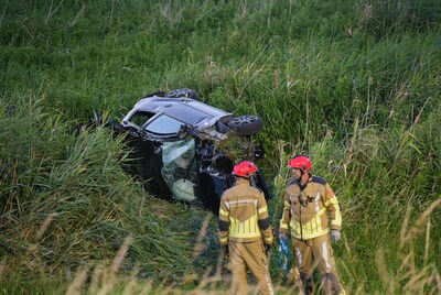 Jonge bestuurder rijdt van tien meter hoge dijk af en raakt zwaargewond, brandweer bevrijdt hem