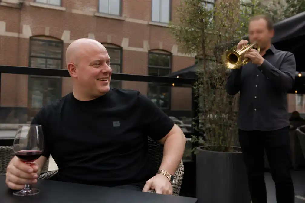 Michael van Gerwen verrast door trompettist op terras in Den Bosch