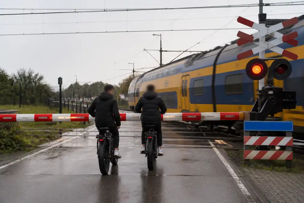 Dashcam toont fatbikers die in Alkmaar door slagboom rijden; trein remt