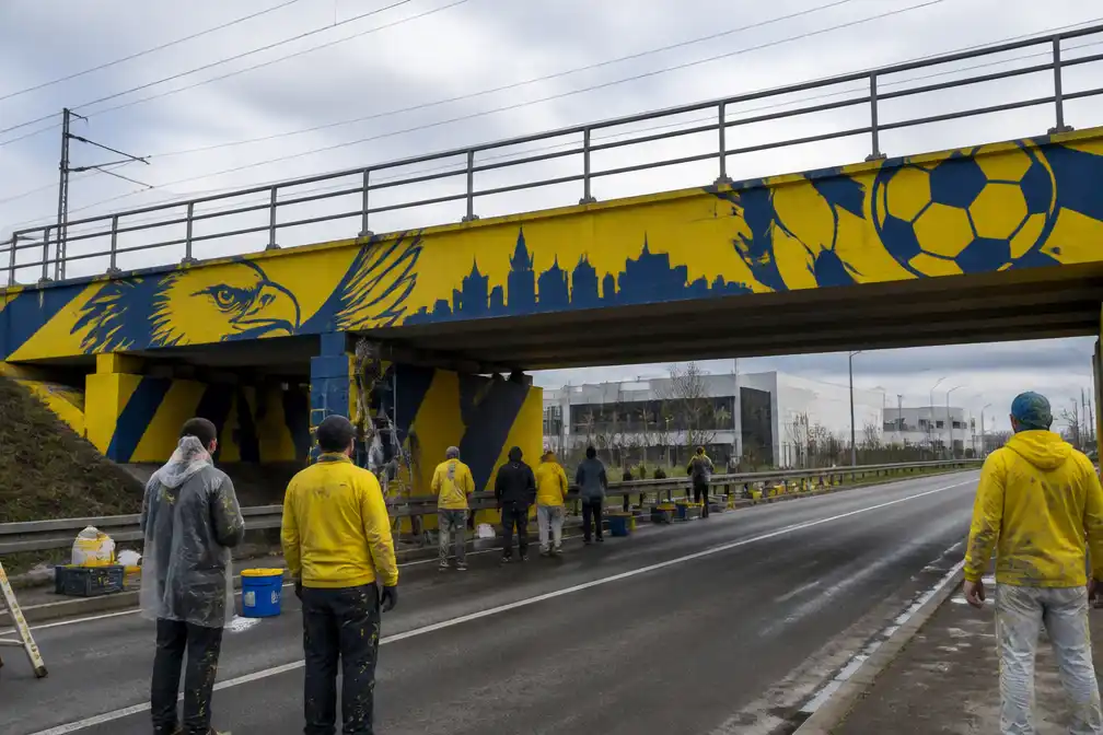 STVV-supporters beschilderen brug bij Stayen geel-blauw voor Trudojaar