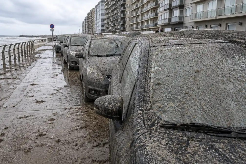 Storm Boelo bedekt geparkeerde wagens op zeedijk Middelkerke met modder