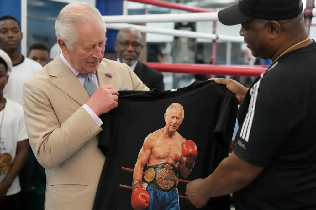 Koning Charles krijgt zwart shirt met eigen afbeelding bij bezoek aan boksschool op Bahama's